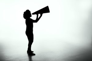 silhouette of woman talking into megaphone