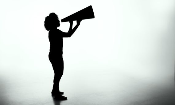 silhouette of woman talking into megaphone