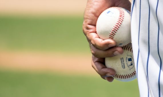 Hand holding two baseballs