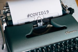 Paper in typewriter with text "#COVID19