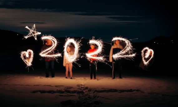 People at night drawing "2022" with sparklers